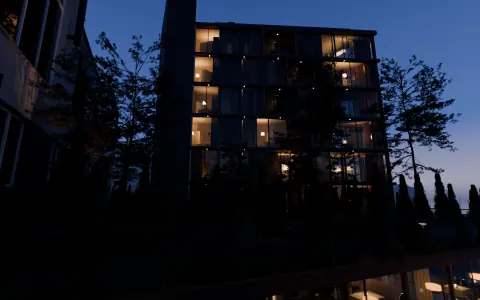 Takhagen på kote 7 med furu og beplantning foran tårnet, skumring