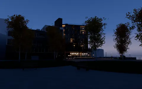 Bygget sett fra torget med bjørk og benker, skumring